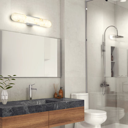 Modern bathroom with a marble countertop, wooden vanity, rectangular mirror, potted plant, toilet, glass-enclosed shower, and an Artika Selena 3 CCT LED bathroom vanity light above the mirror.