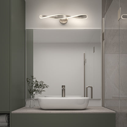 Modern bathroom with a rectangular mirror, white vessel sink, minimalist faucet, and a small glass vase with green branches. Above the mirror is the Artika Finley LED modern bathroom vanity light 3 CCT.