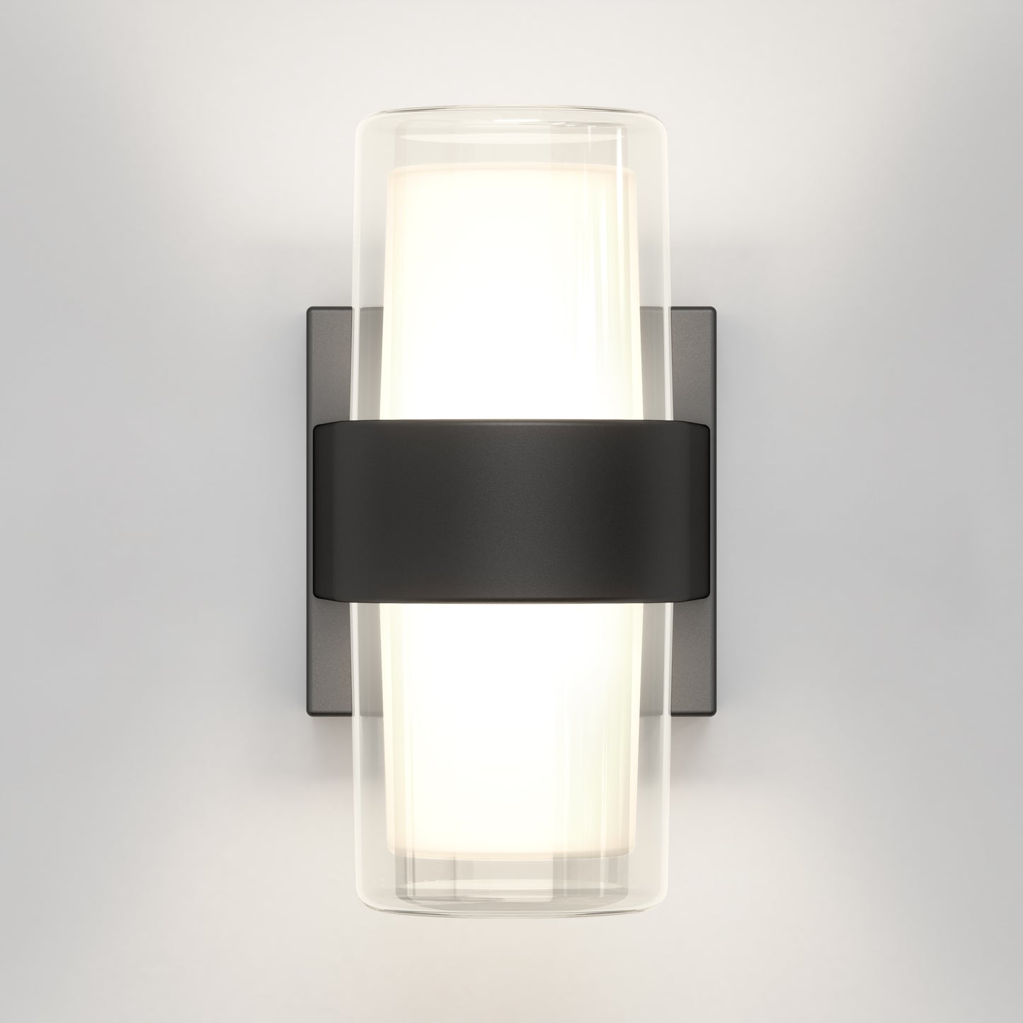 The Artika Colton modern LED indoor-outdoor wall light 5 CCT features a frosted cylindrical glass shade with a black center band and rectangular base, mounted on a light gray wall, casting a soft white glow.