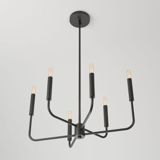 The Artika Manchester 6-light pendant features a modern black finish with six exposed bulbs on sleek, angular arms, suspended elegantly from the ceiling against a white background.