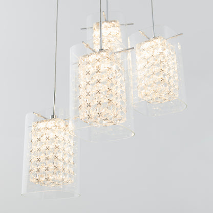 The Artika Crystal Cube 4-light LED pendant light features cylindrical glass shades with crystal-like detailing, suspended against a light gray background and emitting a bright, warm glow.