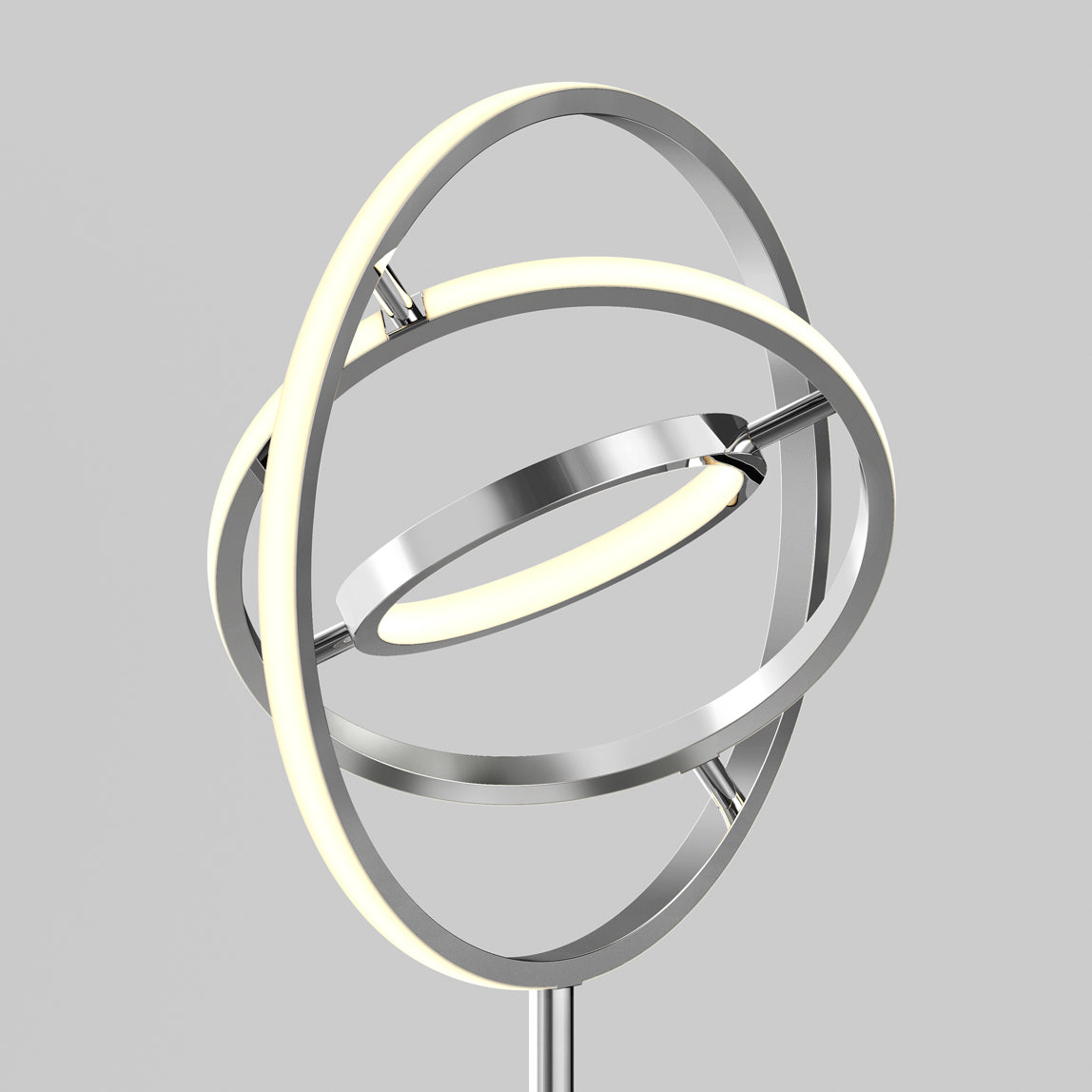 The Artika Pivot modern LED floor lamp 3 CCT features three intersecting metallic rings, two with LED lights, giving it a sculptural and futuristic look against a simple gray backdrop.
