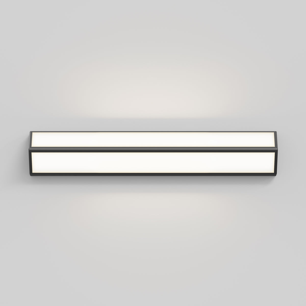A rectangular, wall-mounted light fixture with a minimalist design, emitting a soft white glow, set against a plain light gray background.