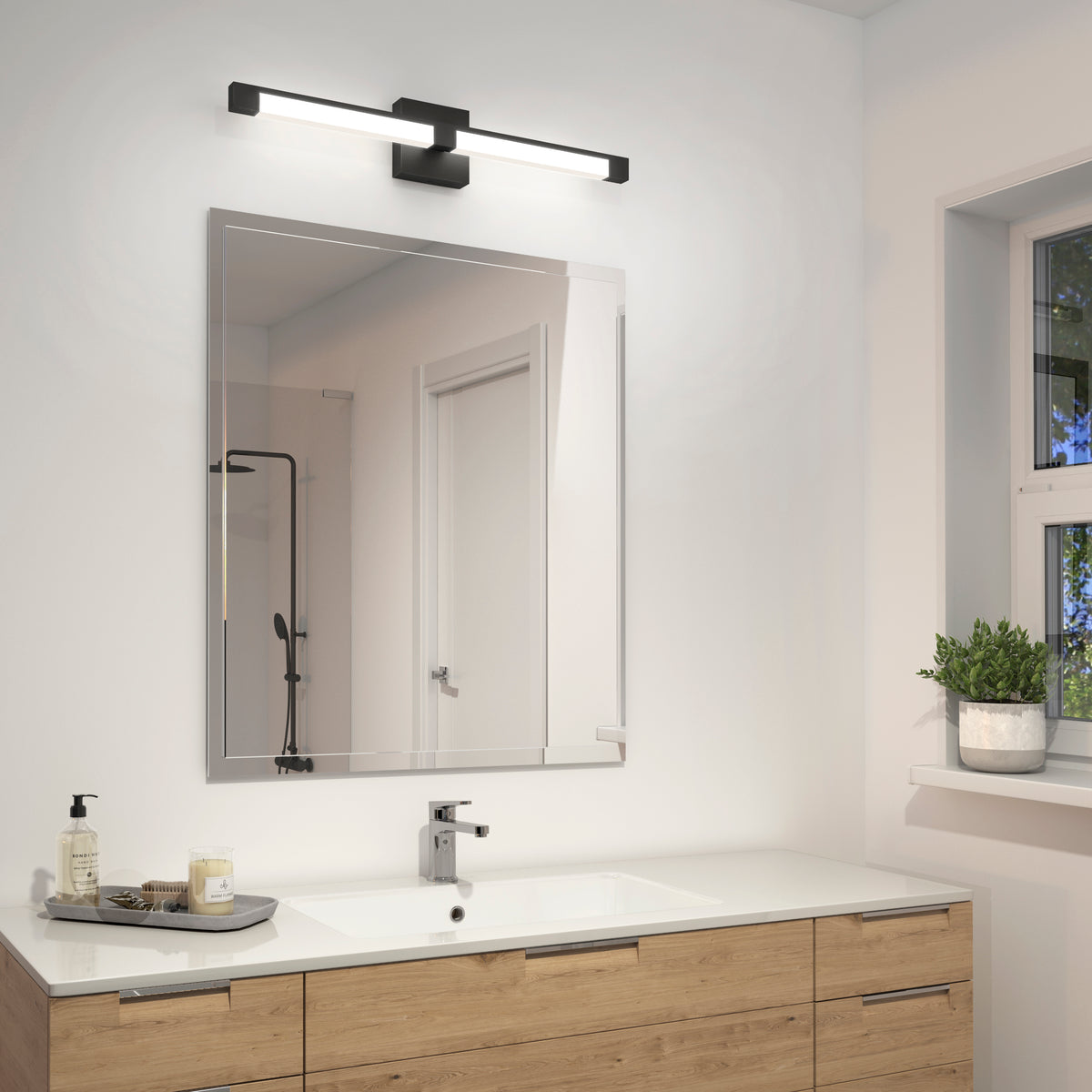 A modern bathroom with a wooden vanity, white countertop, square sink, large wall mirror, sleek black light fixture above the mirror, and a window showing greenery outside.