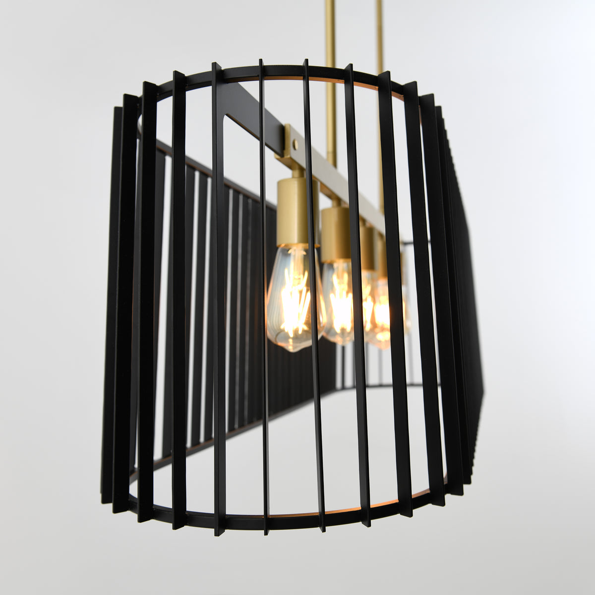 The Artika Gatsby LED pendant light features three exposed bulbs in a black geometric metal frame with vertical bars and gold accents, suspended from the ceiling against a plain background.