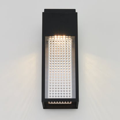 The Artika Meteor LED indoor-outdoor wall light features a modern black rectangular design with a perforated metal front, mounted on a light-colored wall and casting soft upward and downward illumination.