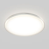A round, flush-mounted ceiling light fixture with a white, illuminated surface and a slim metallic rim, set against a light gray background.
