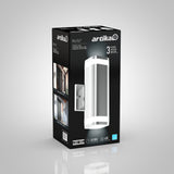 A black product box displays an Artika Mettle outdoor LED wall light, featuring a sleek silver design. The packaging shows the light installed outside a house and highlights product details and specifications.