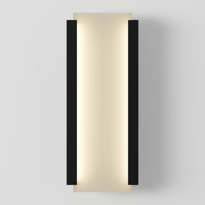 The Artika Blade indoor-outdoor LED wall light features a modern rectangular design with a central frosted panel, emitting soft warm light, framed by two vertical black bars on each side, shown mounted on a white wall.