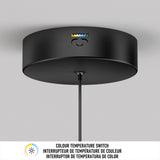 A black ceiling light fixture with a color temperature switch and indicator icons, mounted on a white ceiling. Text below reads: “COLOUR TEMPERATURE SWITCH” in English and French.