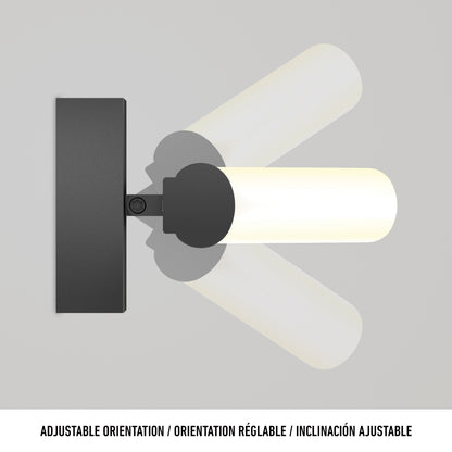 The Arc modern LED bathroom vanity light by Artika, featuring a black wall mount and cylindrical white shade, is shown tilting to display its adjustable orientation. Adjustable Orientation appears below in three languages.