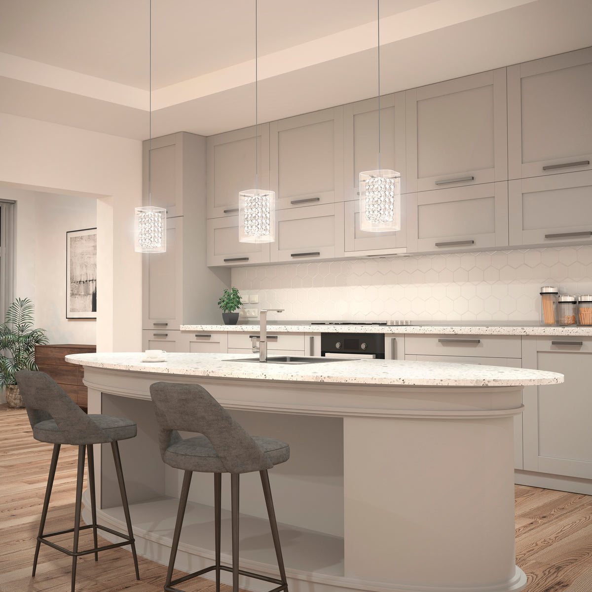 Modern kitchen with light gray cabinets, white countertops, an island with two gray barstools, pendant lights above, and wood flooring. A potted plant and framed art are visible in the background.