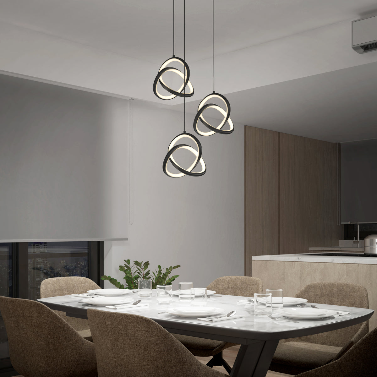 Modern dining room with a marble table set for six, beige upholstered chairs, and three geometric pendant lights hanging above. A plant sits near a window with a city view. The kitchen is visible in the background.