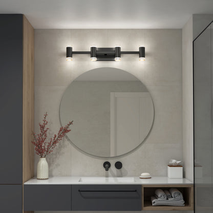 A modern bathroom showcases a round mirror over a white sink with black fixtures, the Artika Mist modern LED bathroom vanity light 5 CCT above, plus a vase with red branches, rolled towels, and neutral-toned cabinetry.