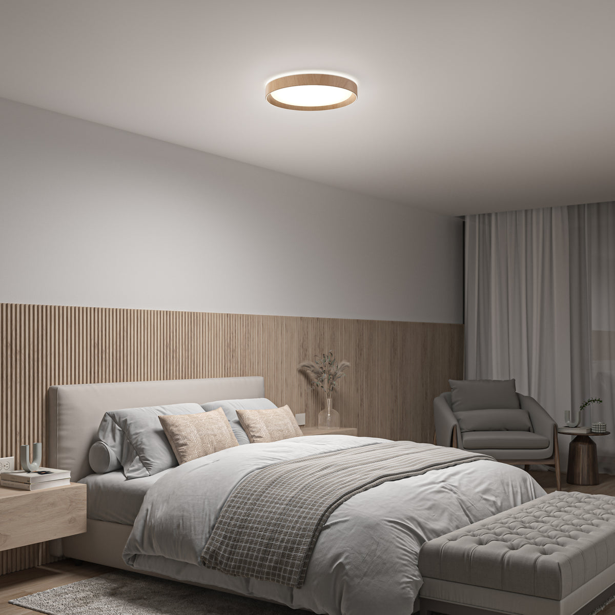 Modern bedroom with neutral tones, featuring a neatly made bed, cushioned bench, armchair with small table, wood panel accent wall, sheer curtains, and a round ceiling light.