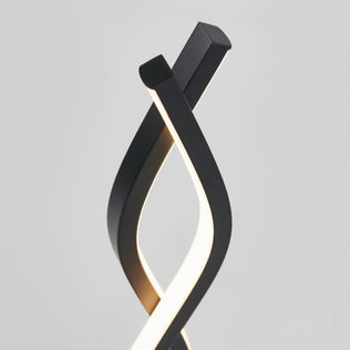 Artikas Wave LED Table Lamp features two modern black curved fixtures that elegantly twist together, emitting a soft glow against a plain gray background.