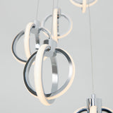 Close-up of modern hanging pendant lights with intertwined metallic rings and integrated LED light strips, suspended by thin cables against a neutral background.