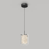 The Artika Crystal Cube 1-light LED pendant light features a black ceiling mount and cord with a cylindrical, textured glass shade that diffuses the light, shown against a plain gray background.