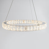 The Artika Celebrity LED pendant light features a modern circular design with square-cut crystals, suspended by thin cables against a light gray background, emitting a soft, elegant glow.