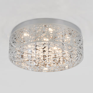 The Artika Crystal Nest LED flush mount is a modern ceiling light with a shiny silver geometric frame and hanging crystal accents, illuminated by multiple LED bulbs.