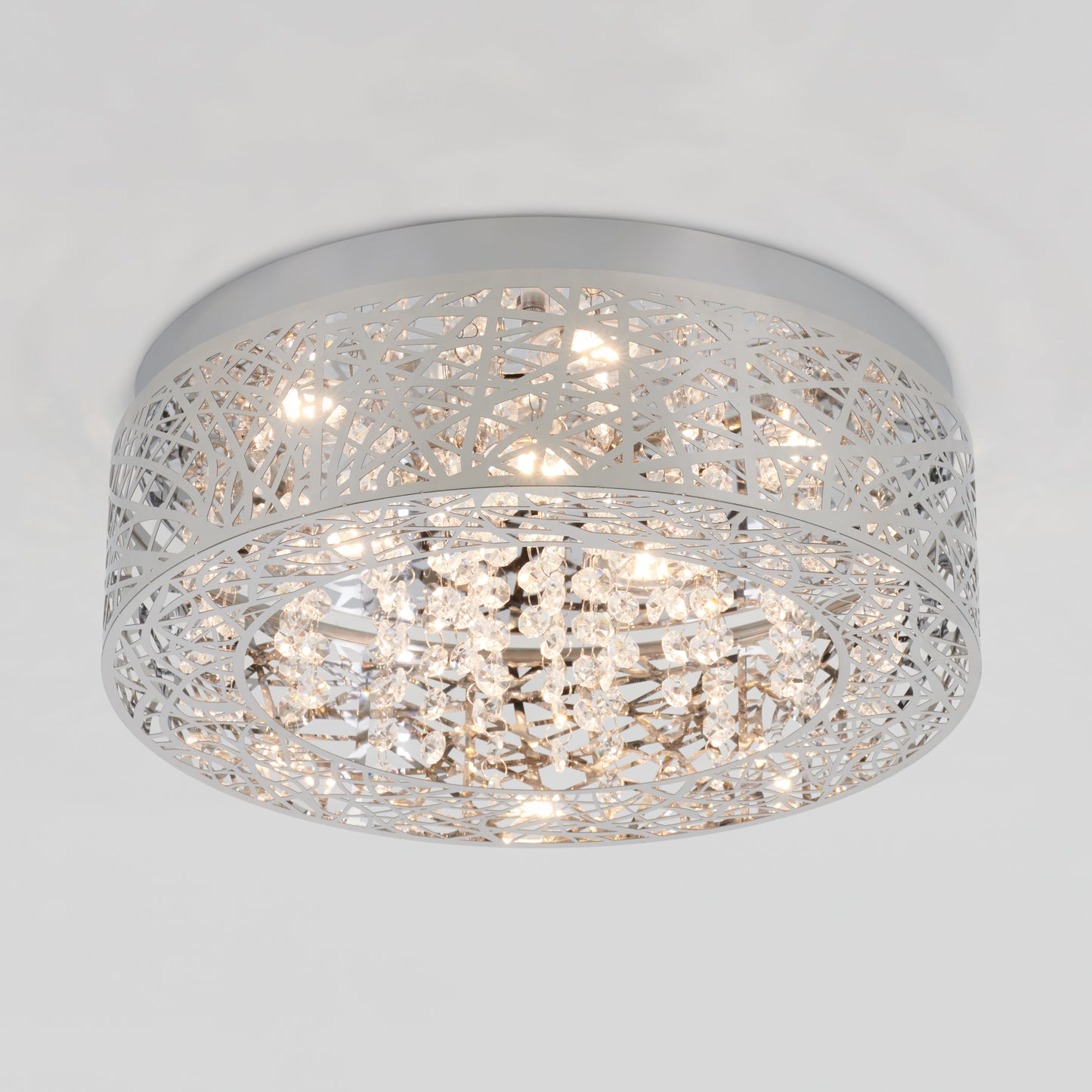 The Artika Crystal Nest LED flush mount features a silver metal lattice design with hanging crystal accents, providing a warm, bright glow.
