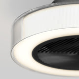 Close-up of a modern circular ceiling light with a ribbed translucent outer rim, a glowing white LED ring, and a black textured center against a light gray background.