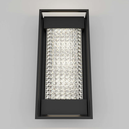 The Artika Glam indoor-outdoor LED wall light features a black metal frame and a central panel of sparkling crystal-like elements, casting bright illumination against any plain gray wall.