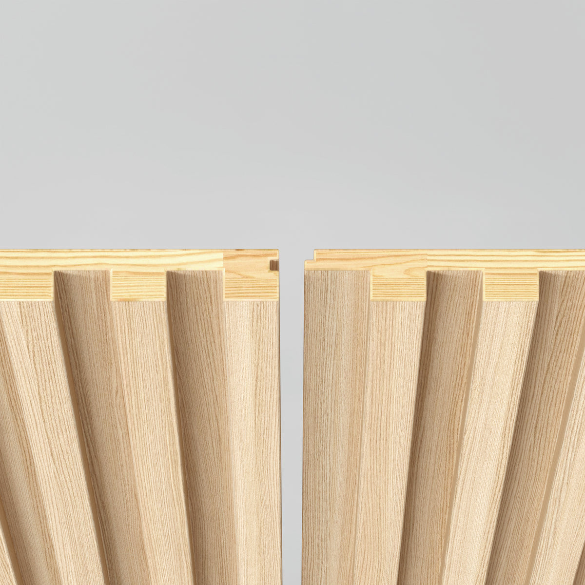 Two interlocking wooden panels with grooved, ribbed surfaces are positioned facing each other against a light gray background, showcasing their joinery design.