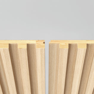 The Artika Panolok 30.67 ft wall panel kit (pack of 8) features two light wood panels with interlocking grooves and ridges, vertically aligned against a plain gray background, showcasing precise joinery and Scandinavian style.