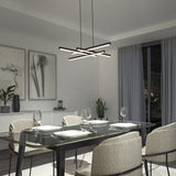 Modern dining room with a glass table set for four, beige upholstered chairs, abstract wall art, potted plants, and a contemporary geometric chandelier hanging from the ceiling. Large window with sheer gray curtains.