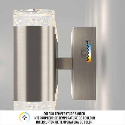 The Artika Mist modern LED bathroom vanity light 5 CCT is a wall-mounted fixture with a cylindrical metallic body, bubble-filled glass ends, a side color temperature switch, and multilingual labeling below.