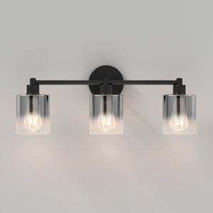 The Artika Haze modern 3-light bathroom vanity light features three exposed bulbs in clear cylindrical glass shades, shown mounted on a light gray wall.