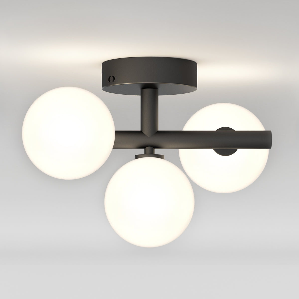 A modern ceiling light fixture with three white frosted glass globes arranged in a triangular pattern, attached to a black metal base and arms, mounted on a white ceiling.