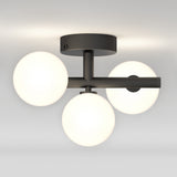 A modern ceiling light fixture with three white frosted glass globes arranged in a triangular pattern, attached to a black metal base and arms, mounted on a white ceiling.