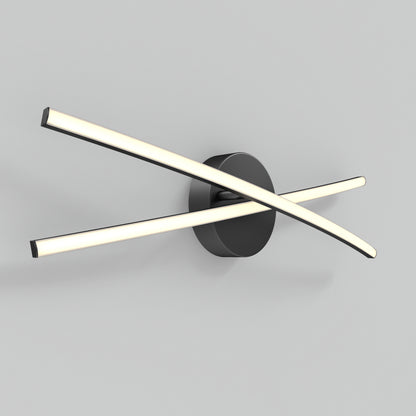 The Orly modern LED bathroom vanity light by Artika features two slim, illuminated bars crossing at an angle on a round black base, creating a sleek look against a light gray wall.