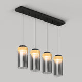 A modern ceiling light fixture with four hanging pendant lights, each featuring a cylindrical glass shade and a wooden accent at the top, suspended from a rectangular black base.