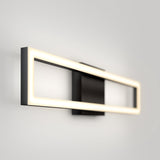A modern wall-mounted rectangular LED light fixture with a black base and a glowing rectangular frame, set against a plain light gray wall.