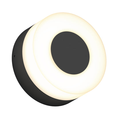 The Artika Ludwig modern LED indoor-outdoor wall light 5CCT features a round design with a black center and base, encircled by a glowing white ring, shown at an angle on a white background.