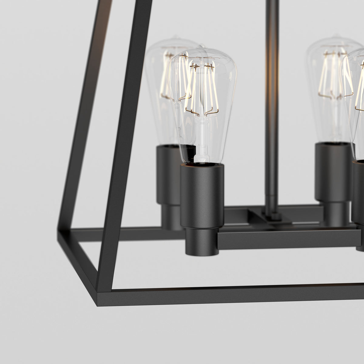 Close-up of a modern black metal chandelier with exposed vintage-style bulbs, featuring a geometric open frame design against a plain light background.