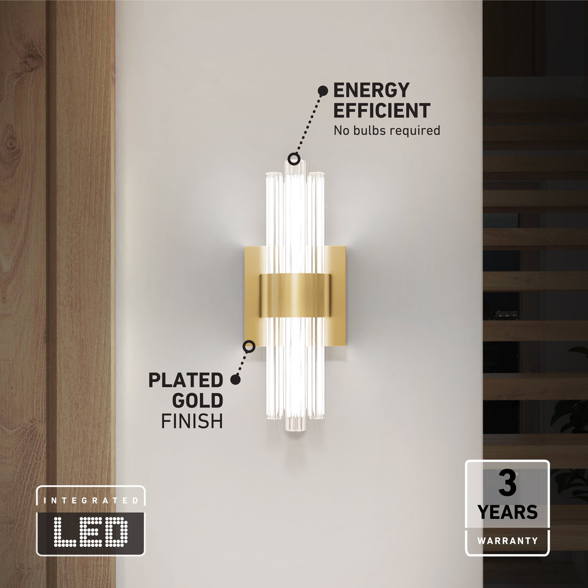 A modern wall sconce with a plated gold finish and integrated LED lights is mounted on a white wall. Text highlights its energy efficiency, no bulb requirement, and a 3-year warranty.