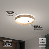 Circular ceiling light with a painted wood finish, emitting a soft glow. Text highlights its energy efficiency (no bulbs required) and a 5-year warranty. Integrated LED is noted in the bottom left corner. Modern interior setting.
