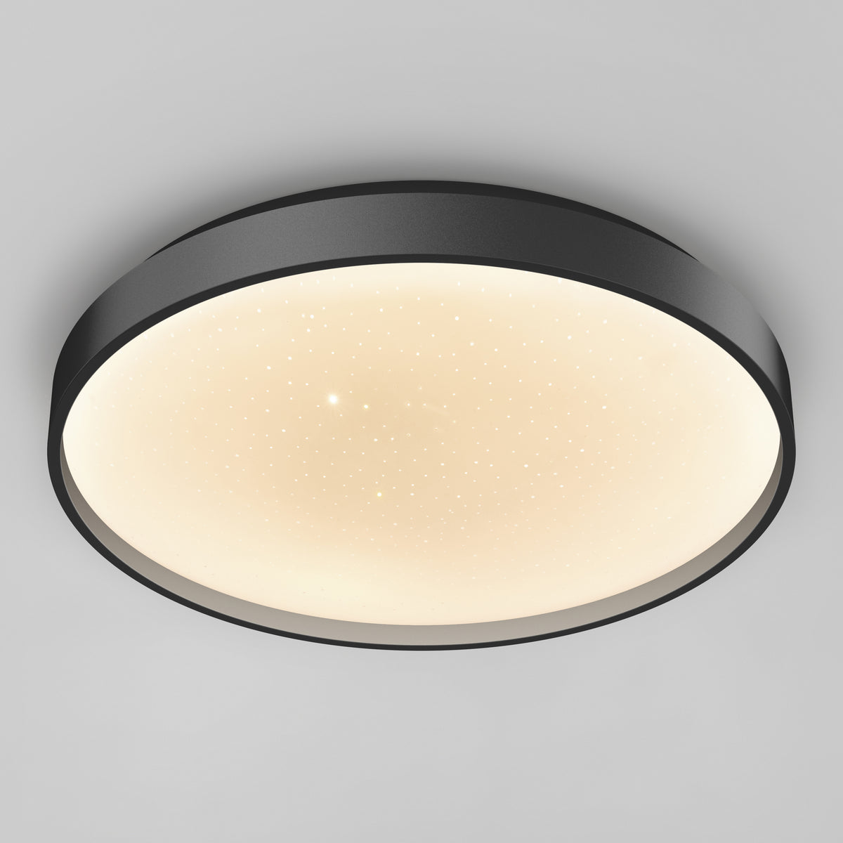 The Artika Celestia 15 in. modern LED flush mount light features a black frame, glowing white diffuser with star-like dots, and comes with a remote—shown mounted on a plain light gray ceiling.