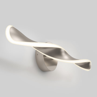 The Artika Finley LED modern bathroom vanity light 3 CCT features a sleek, twisted metallic design and emits a soft edge glow, making it a stylish wall-mounted fixture against any plain gray background.