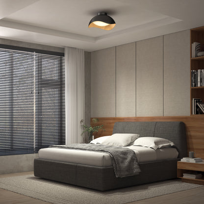 Modern bedroom with a grey upholstered bed, white bedding, checkered blanket, wood panel walls, built-in shelves, large window with blinds, and an Artika Adara 15 in. LED flush mount light with 5 CCT settings on the ceiling.