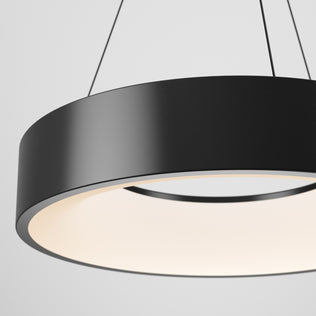 The Artika Aiden LED pendant light features a minimalist black circular design, suspended by thin wires, casting a soft, diffused glow downward against a plain white backdrop.