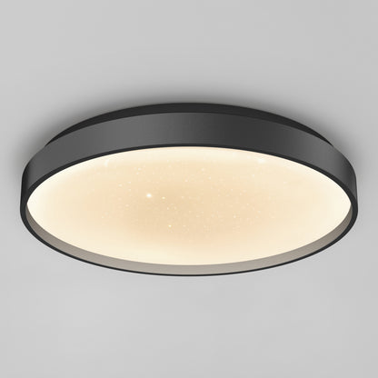 The Artika Celestia 15 in. modern LED flush mount light features a black frame, softly glowing white star-patterned diffuser, and comes with a remote, shown mounted on a plain light gray ceiling.
