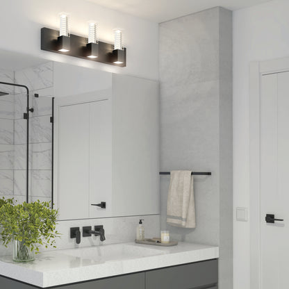 Modern bathroom with a rectangular mirror, black fixtures, white countertop, potted plant, towel on a black towel bar, and the Artika Hologram LED modern bathroom vanity light 5 CCT above the mirror.