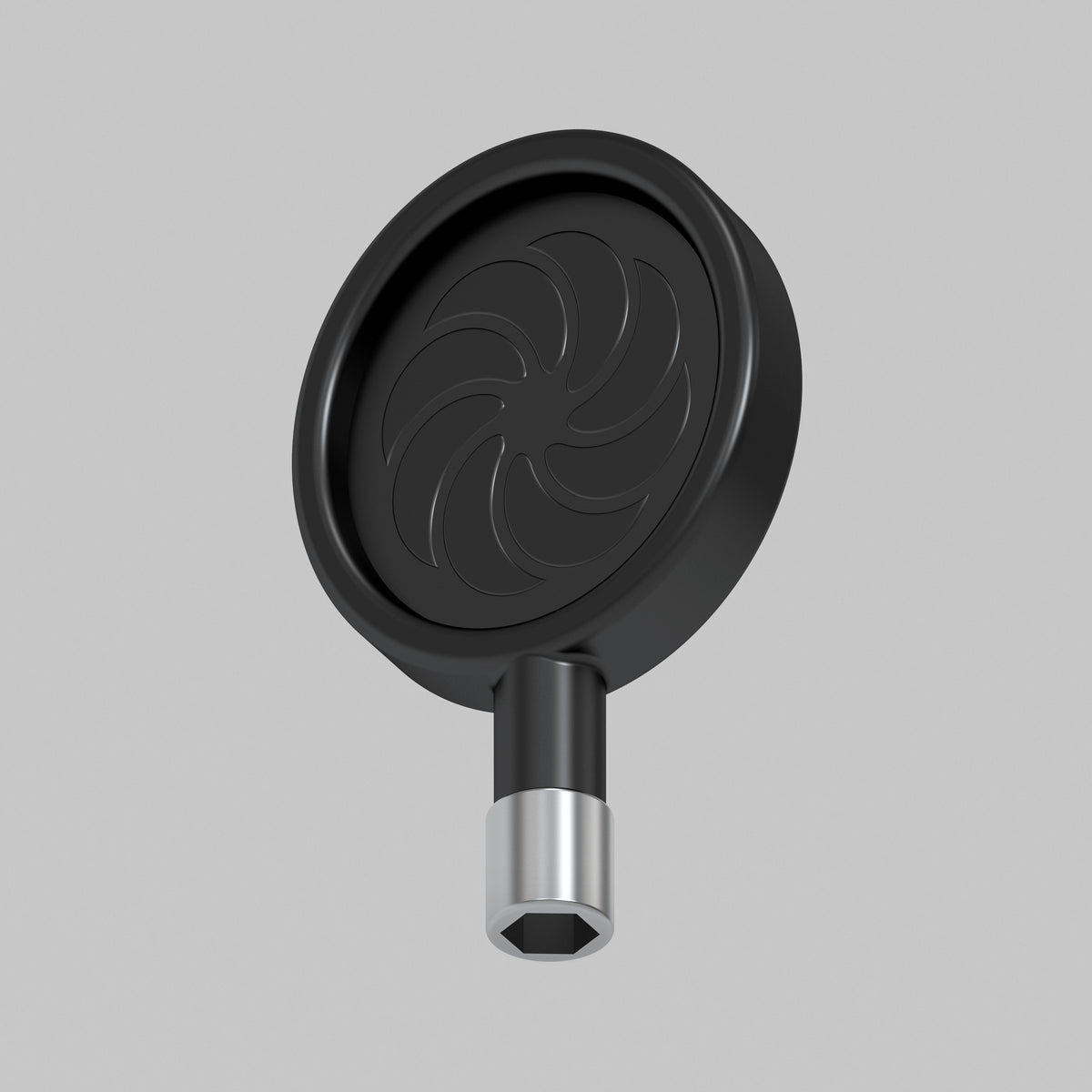 A black circular tool with a spiral pattern on its face and a silver metallic hexagonal connector at the bottom, shown against a plain light gray background.
