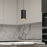 Modern kitchen with light gray marble backsplash and countertop, white upper cabinets, a black cylindrical pendant light hanging from the ceiling, and part of a built-in oven visible on the right.
