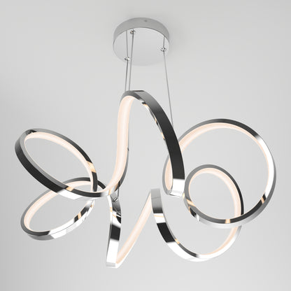 The Artika Swirl Ribbon LED pendant light features intertwined metallic bands with integrated LED strips, suspended by two wires from a round chrome ceiling mount, creating a modern look.